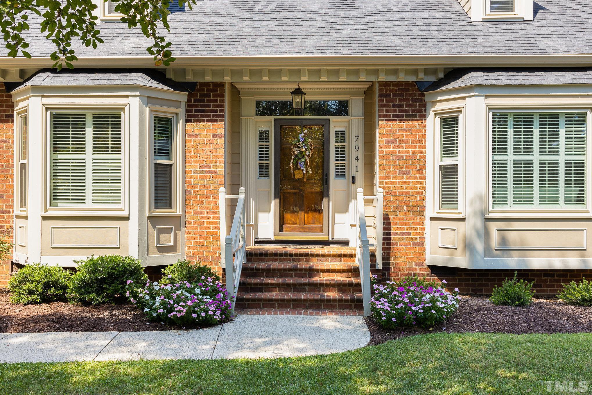 a front view of a house with a garden and plants