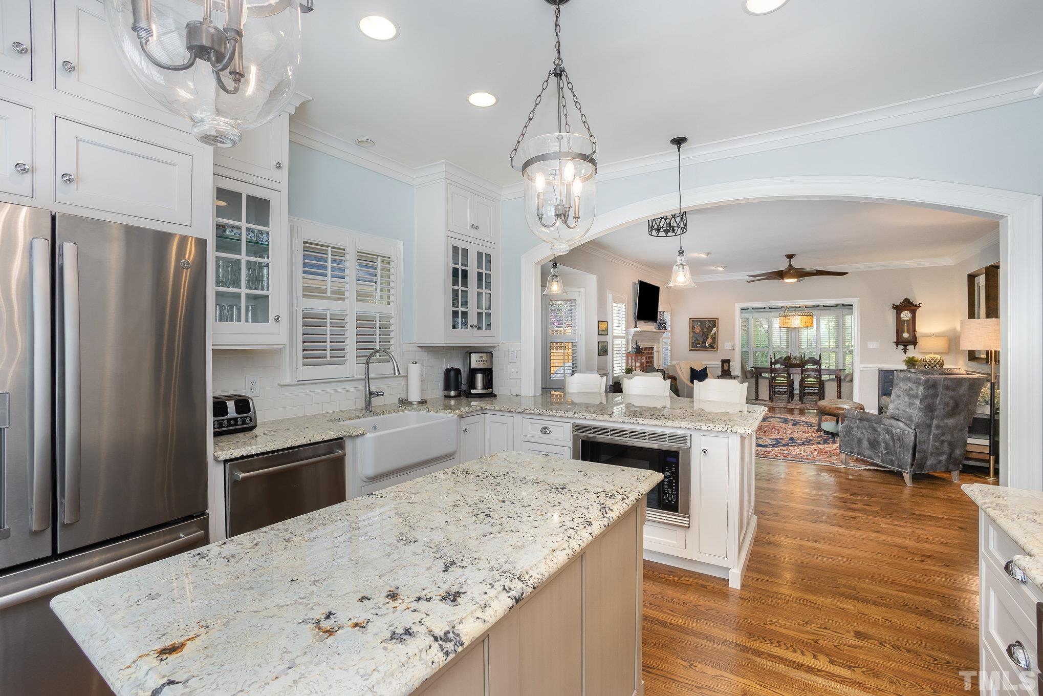 7941 Footman Way Raleigh, NC 27615 - Photo 12 of 41 a large kitchen with a center island wooden floor and stainless steel appliances
