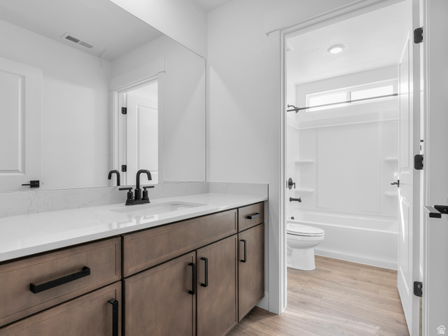 1380 West 2350 South, Unit 16 Perry, UT 84302 - Photo 24 of 34 White countertop with integrated sink, black hardware, wood-finish cabinetry, full-width mirror, and a full bath with a window