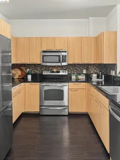 a kitchen with stainless steel appliances a stove a sink and white cabinets