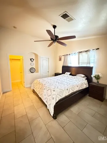 a bedroom with a bed and dresser with mirror