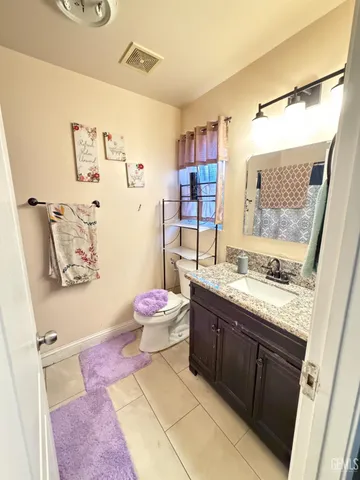 a spacious bathroom with a granite countertop sink and a mirror