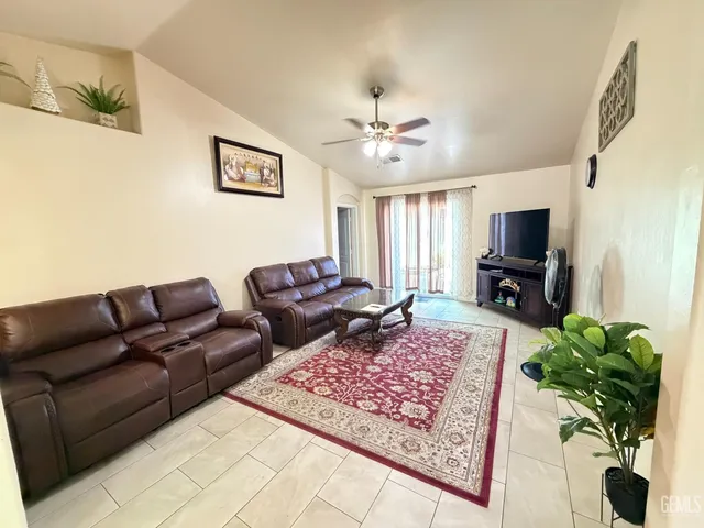 a living room with furniture flowers and a flat screen tv