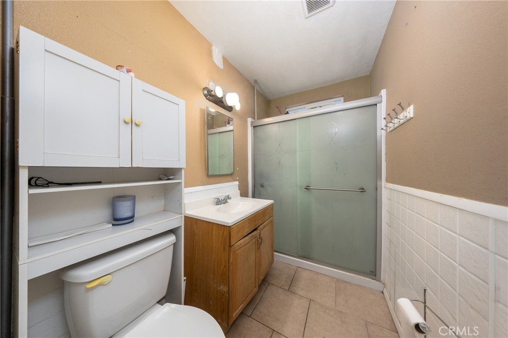566 South Sage Avenue Rialto, CA 92376 - Photo 17 of 28 a bathroom with a sink a toilet a mirror and shower