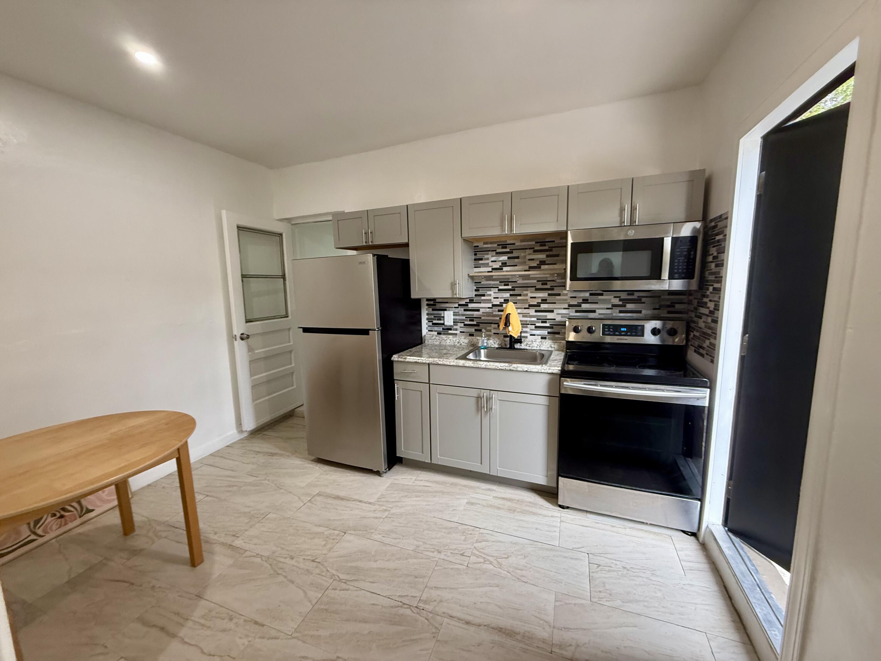 310 Washington Avenue Delray Beach, FL 33444 - Photo 1 of 16 a kitchen with stainless steel appliances a refrigerator stove microwave and sink