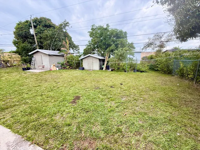 a tall yellow house with a yard