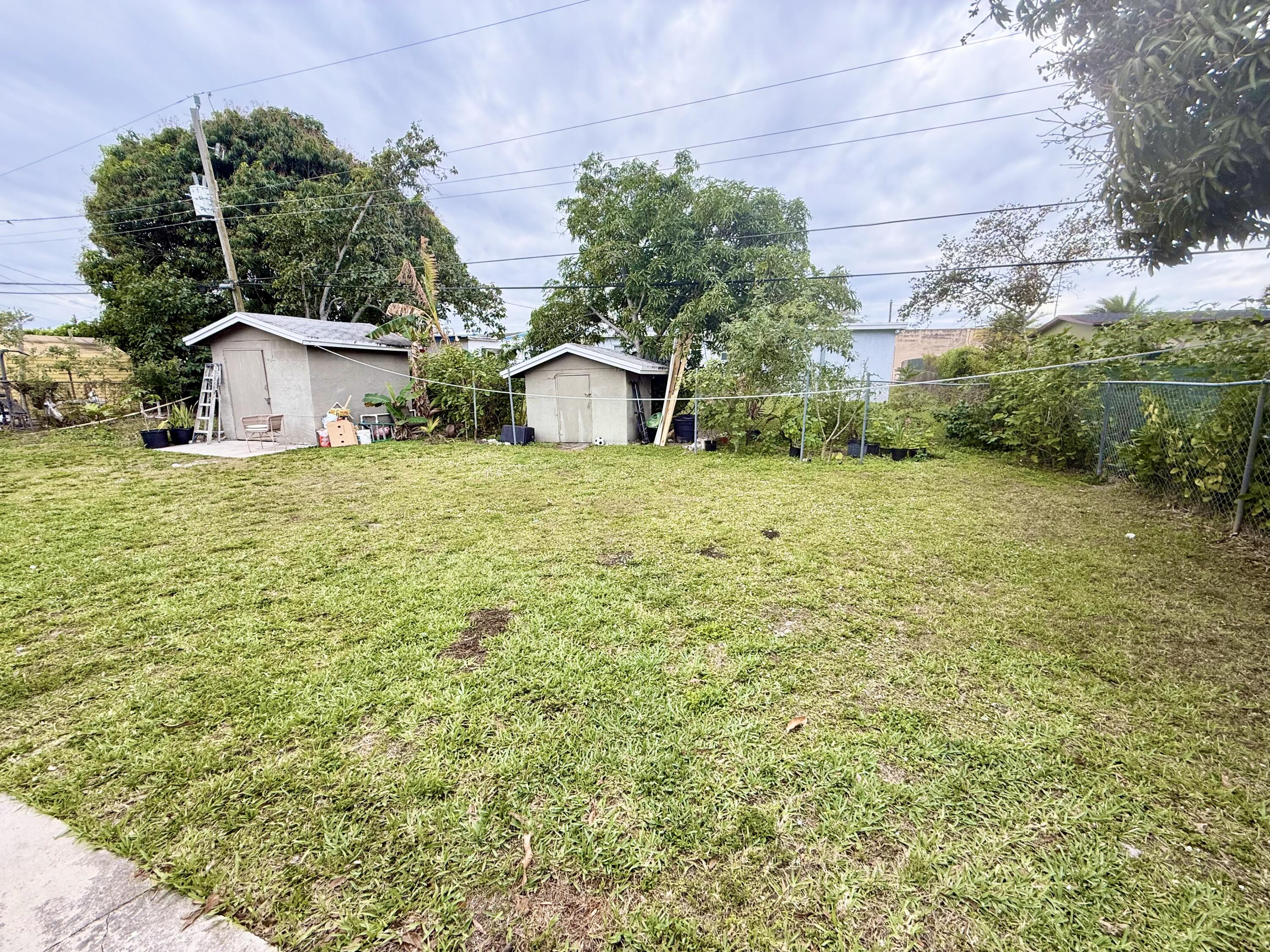 310 Washington Avenue Delray Beach, FL 33444 - Photo 11 of 16 a tall yellow house with a yard