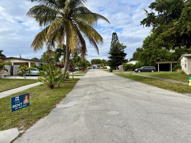 front view of house with a yard and potted plants