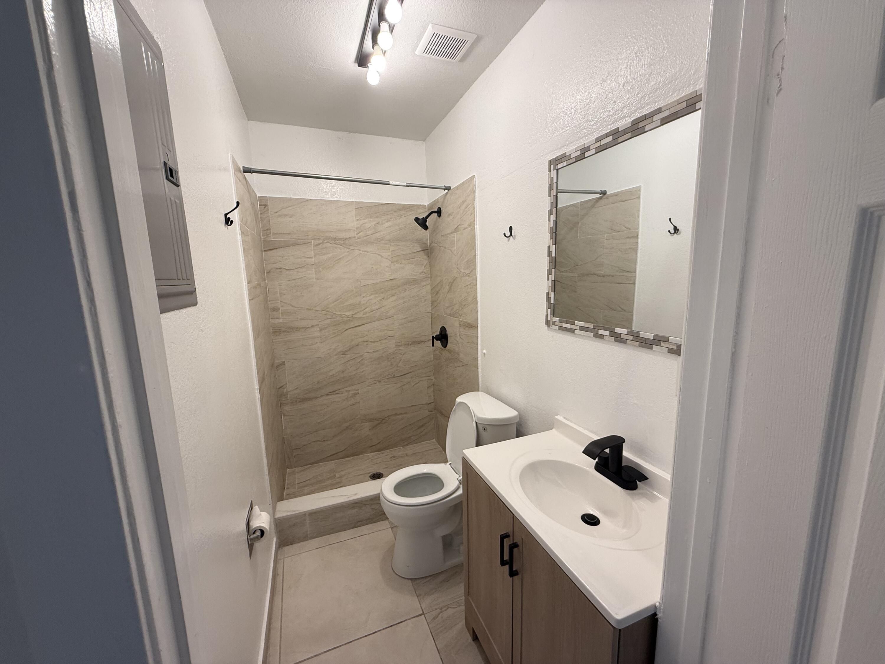 310 Washington Avenue Delray Beach, FL 33444 - Photo 2 of 16 a bathroom with a toilet sink and a mirror