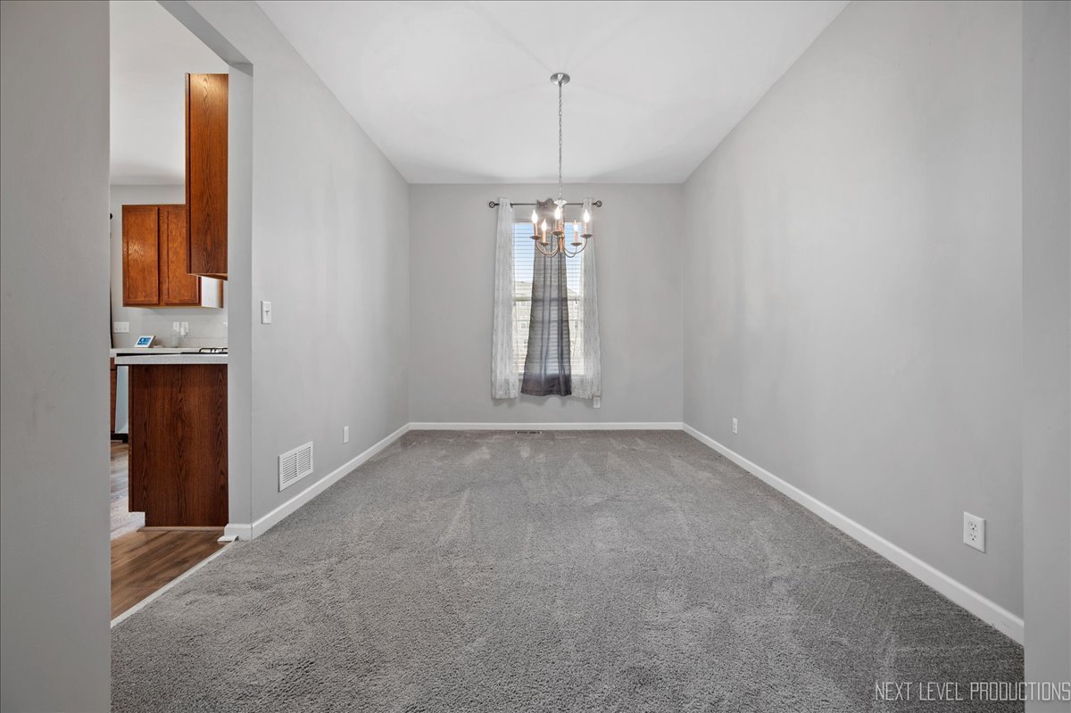 442 Windett Ridge Road Yorkville, IL 60560 - Photo 12 of 43 an empty room with chandelier fan and windows
