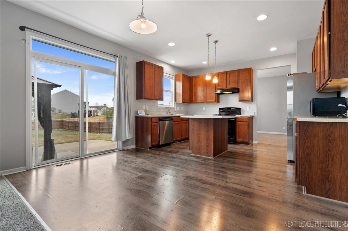 442 Windett Ridge Road Yorkville, IL 60560 - Photo 17 of 43 a large kitchen with stainless steel appliances granite countertop a stove and a view of living room