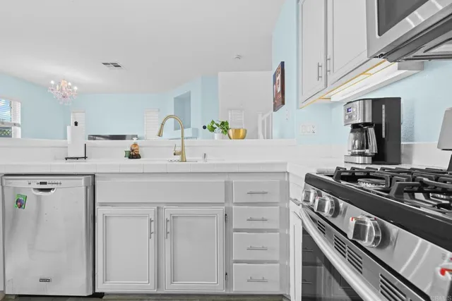 a kitchen with white cabinets and appliances