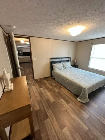 a bedroom with a bed and a flat tv screen on dresser