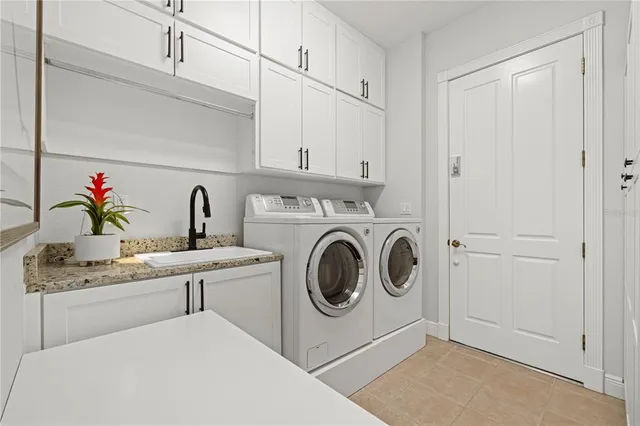 a utility room with sink dryer and washer