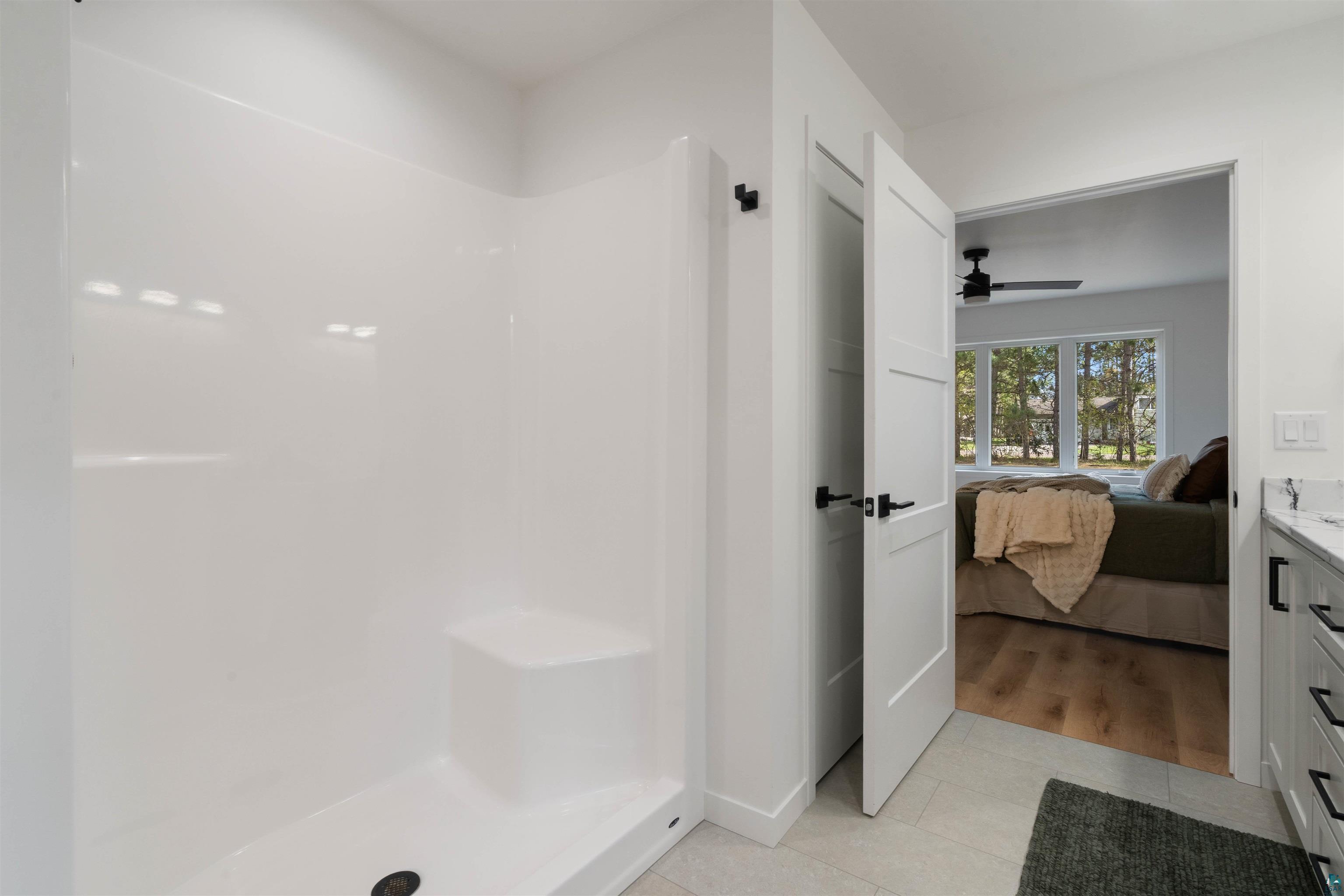 1386 Stephen Road Cloquet, MN 55720 - Photo 19 of 25 White shower enclosure with an integrated seating bench