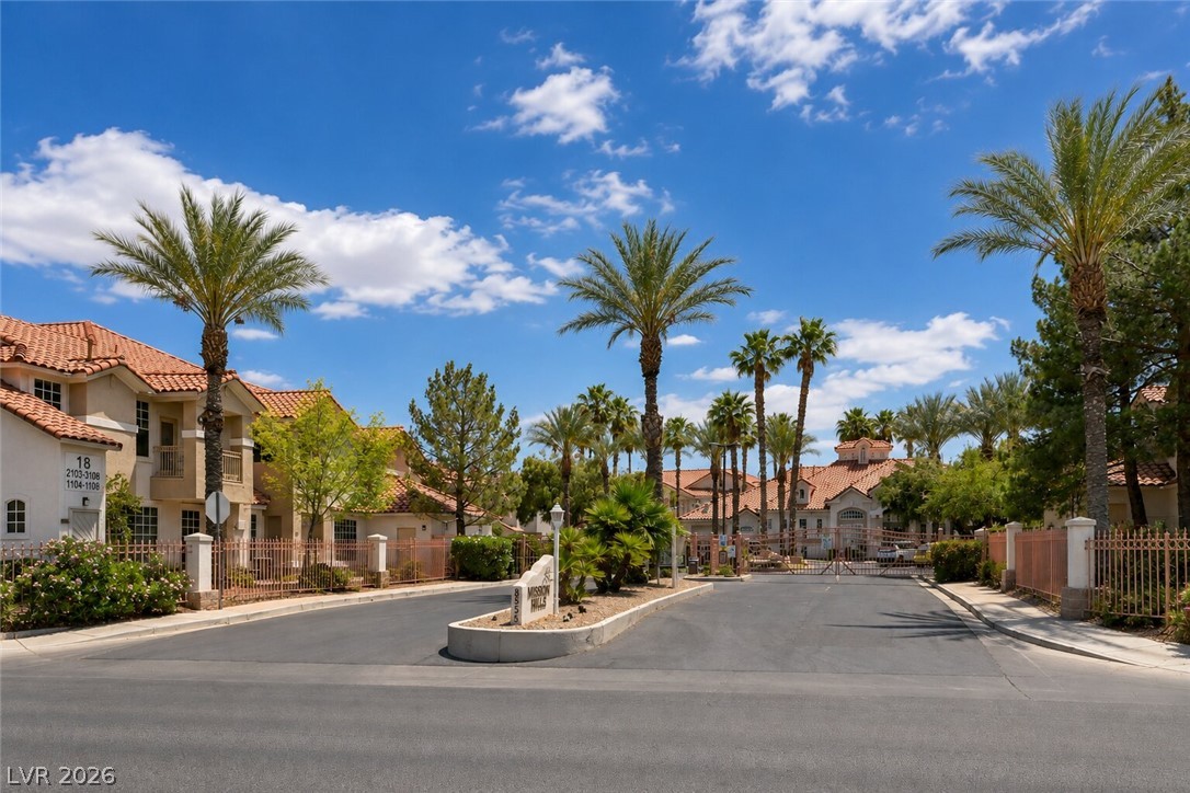 8555 West Russell Road, Unit 2069 Las Vegas, NV 89113 - Photo 2 of 27 A community entry with palm trees and a vibrant blue sky creates an inviting, resort-like atmosphere.