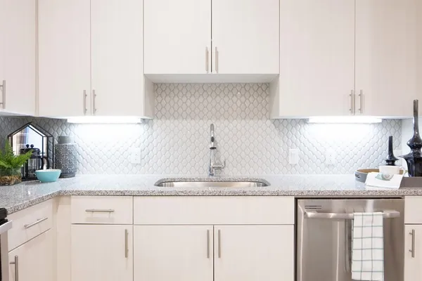 a kitchen with granite countertop white cabinets and a sink