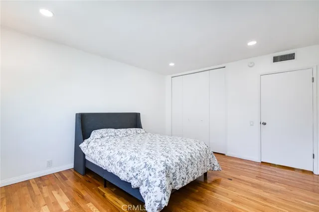 a bedroom with a bed and wooden floor