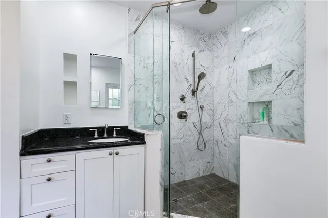 a bathroom with a granite countertop sink a shower and a mirror