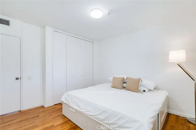a bedroom with a bed and wooden floor