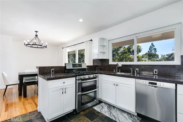 a kitchen with stainless steel appliances a sink a stove and a large window