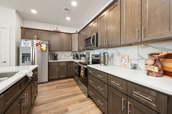 a kitchen with stainless steel appliances granite countertop a stove a microwave and cabinets