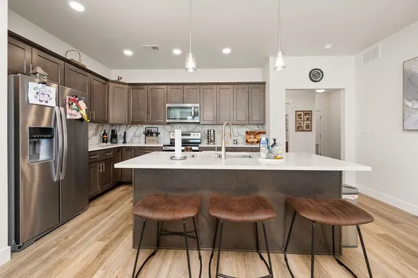 a kitchen with a table chairs refrigerator and cabinets