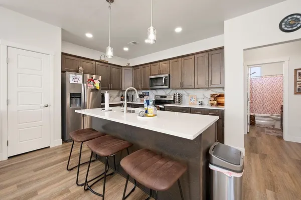 a kitchen with a sink a counter top space a large window and stainless steel appliances