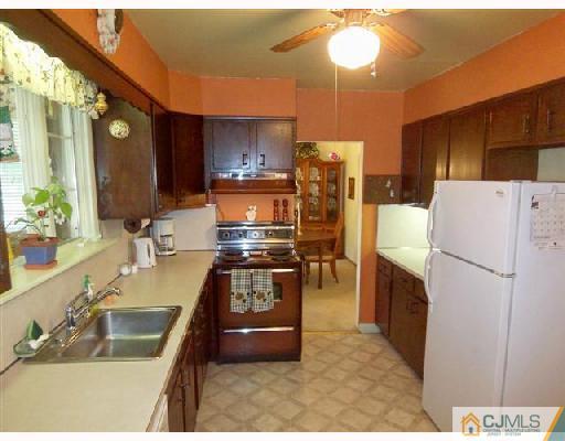 15 Morningside Road Colonia, NJ 07067 - Photo 6 of 8 a kitchen with refrigerator and cabinets