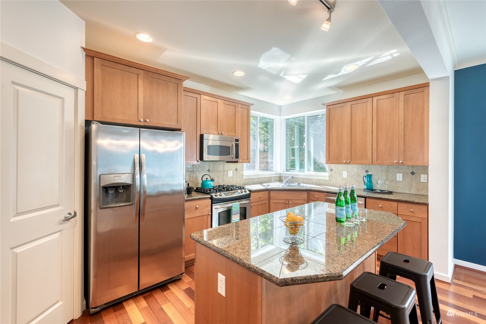 569 Alpine Ridge Place Northwest Issaquah, WA 98027 - Photo 13 of 35 a kitchen with stainless steel appliances granite countertop a refrigerator a sink a stove a dining table and chairs