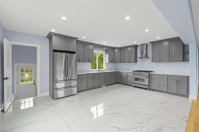 a kitchen with stainless steel appliances a refrigerator and a stove top oven