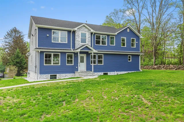 a front view of a house with a garden and yard