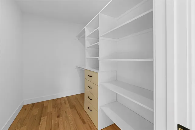 a view of walk in closet with empty racks