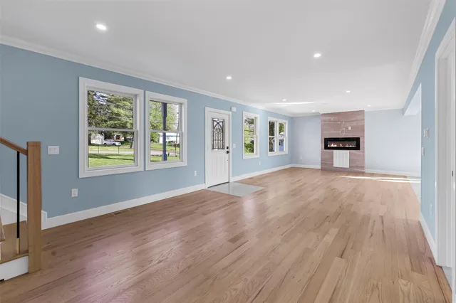 an empty room with windows and fireplace