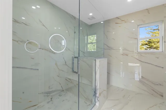 a bathroom with a shower a sink and a mirror