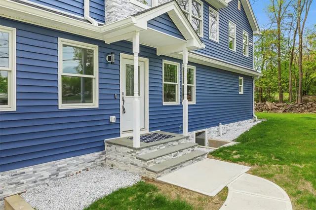 a view of a house with a yard and sitting area
