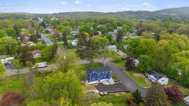an aerial view of residential houses with outdoor space and trees