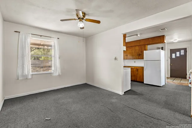 a view of kitchen with furniture and refrigerator