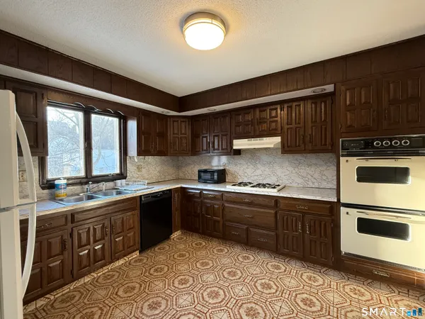 a kitchen with stainless steel appliances granite countertop a stove sink and cabinets