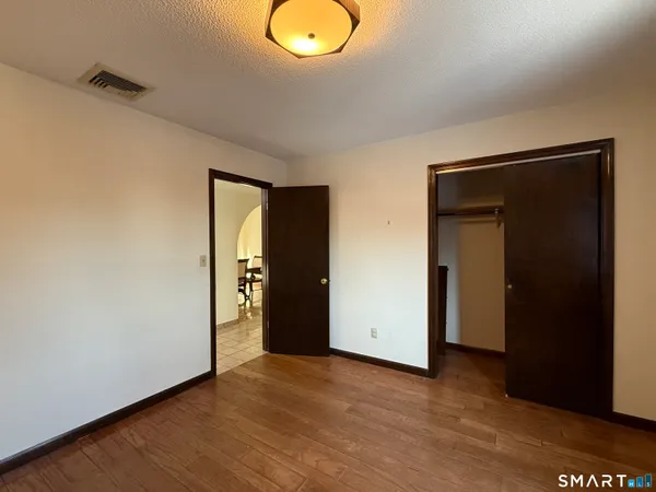 an empty room with wooden floor and closet