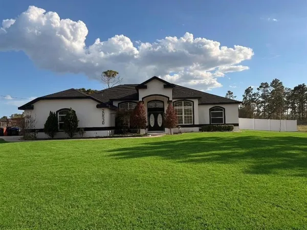 a front view of a house with garden and yard