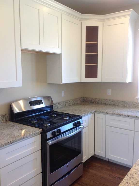 160 Edgell Road Framingham, MA 01701 - Photo 5 of 10 a kitchen with granite countertop white cabinets appliances and a window