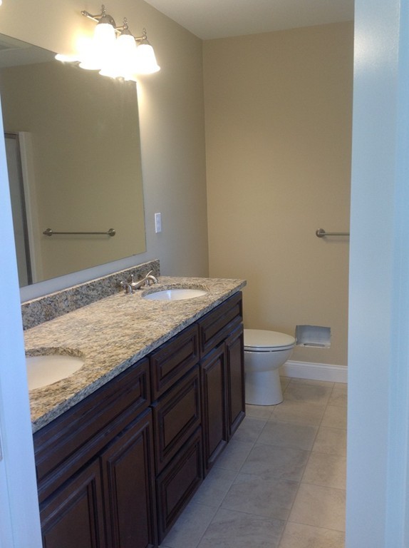 160 Edgell Road Framingham, MA 01701 - Photo 9 of 10 a bathroom with a granite countertop sink a toilet and a mirror