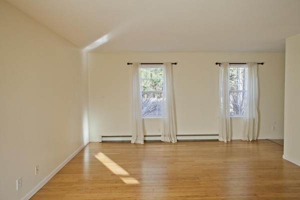 408 Bridge Road, Unit B Northampton, MA 01062 - Photo 10 of 22 an empty room with wooden floor and windows