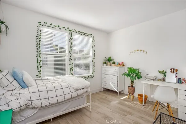a bedroom with a bed table chair and a window