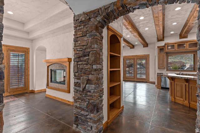 2464 East Granite Way St. George, UT 84790 - Photo 39 of 106 Unfurnished formal dining room, living room, and kitchen with recessed lighting, concrete floors, a fireplace, arched walkways, and french doors