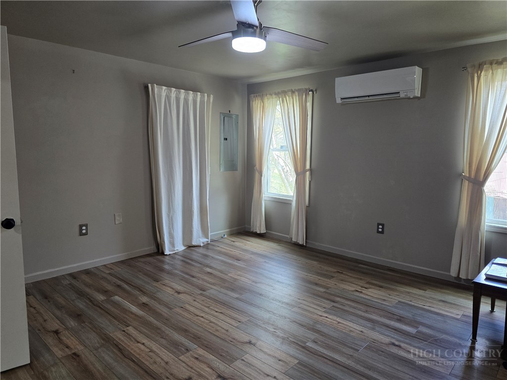 325 Sawyers Road Warrensville, NC 28693 - Photo 28 of 39 an empty room with wooden floor and windows