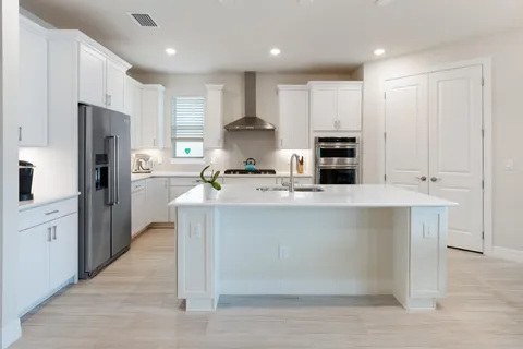 a kitchen with white cabinets and stainless steel appliances