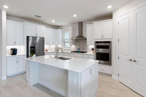 a kitchen with stainless steel appliances kitchen island granite countertop a stove a sink a microwave a counter top and cabinets