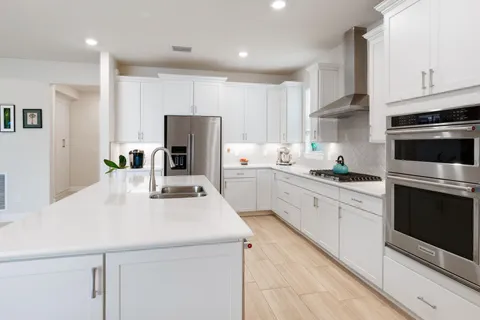 a kitchen with stainless steel appliances and white cabinets